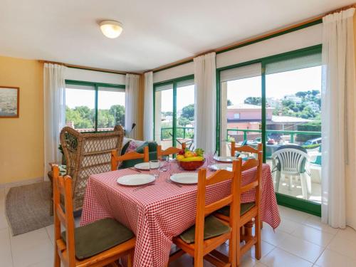 リャンサにあるApartment Mediterrani-5 by Interhomeのテーブルと椅子と窓のあるダイニングルーム