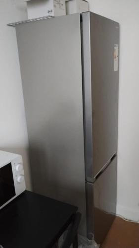 - un réfrigérateur en acier inoxydable dans une cuisine à côté d'une table dans l'établissement Appartement Familial 5 pers, à Montgeron