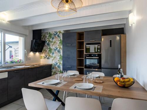 une cuisine avec une table en bois et des chaises ainsi qu'une salle à manger dans l'établissement Holiday Home La Roselière by Interhome, à Guissény