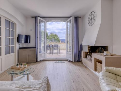 - un salon avec une porte s'ouvrant sur une terrasse dans l'établissement Apartment Hameau la Madrague-28 by Interhome, à Saint-Cyr-sur-Mer