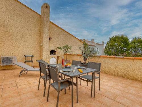 un patio avec une table et des chaises sur un patio dans l'établissement Apartment Hameau la Madrague-28 by Interhome, à Saint-Cyr-sur-Mer
