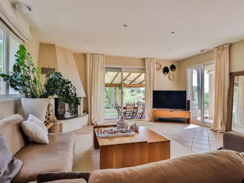 un salon avec un canapé et une télévision dans l'établissement Holiday Home La pinède by Interhome, à Thèzan-lès-Béziers