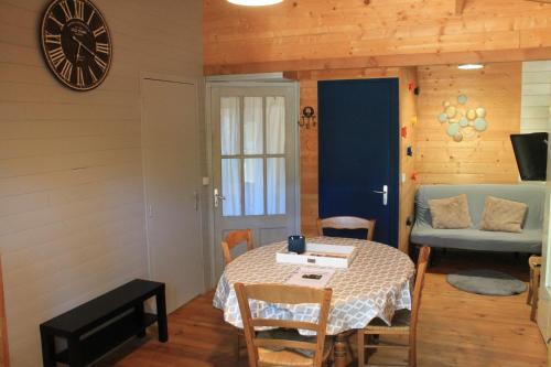 une salle à manger avec une table et une horloge au mur dans l'établissement Gîte sous le Tilleul, Luberon, à Croagnes