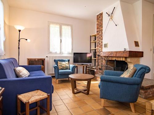 un salon avec des chaises bleues et une cheminée dans l'établissement Holiday Home L'Agapanthe by Interhome, à Figanières