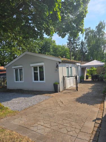 a small white house with a fence at T'chaletje met hottub in Lanaken