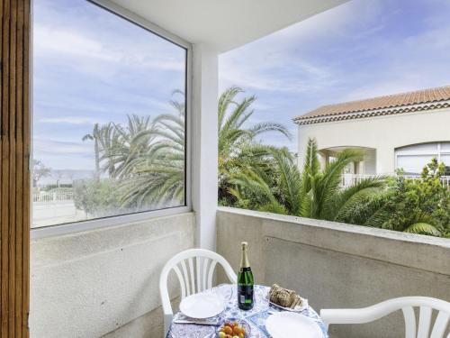 - une table avec une bouteille de vin sur le balcon dans l'établissement Apartment Super Plage-5 by Interhome, à Saint-Cyr-sur-Mer