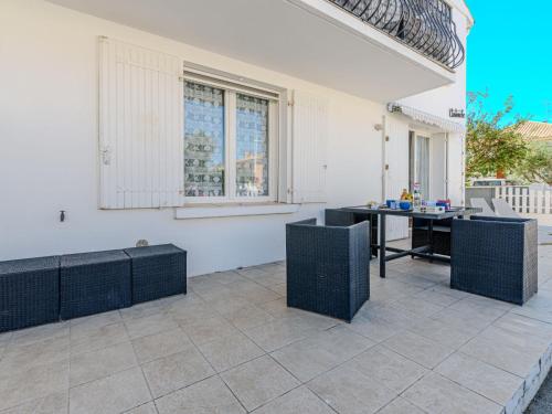 un patio avec une table, des chaises et une fenêtre dans l'établissement Apartment Villa Cartouche by Interhome, au Grau-du-Roi