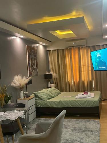a bedroom with a bed and a flat screen tv at Aura Suite in Imus