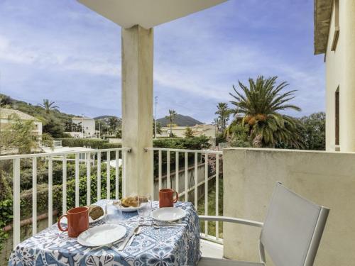- une table avec des assiettes sur un balcon avec vue dans l'établissement Apartment Super Plage-7 by Interhome, à Saint-Cyr-sur-Mer