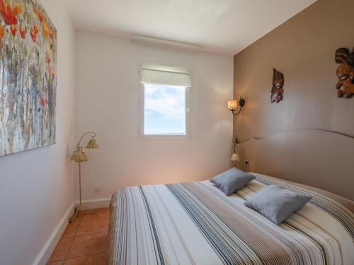 une chambre avec un lit avec deux oreillers dessus dans l'établissement Apartment Résidence Bellevue-2 by Interhome, à Roquebrune-sur Argens
