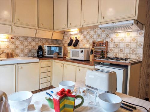 une cuisine avec des armoires blanches et un comptoir dans l'établissement Apartment La côte du Parc-1 by Interhome, à Saint-Gervais-les-Bains