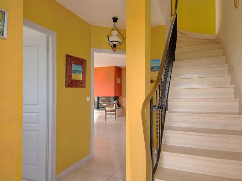 un couloir avec un escalier dans une maison aux murs jaunes dans l'établissement Holiday Home Charme de Penvins by Interhome, à Sarzeau