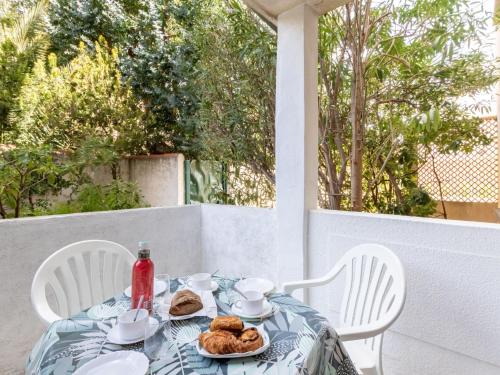 une table avec une assiette de nourriture sur une terrasse couverte dans l'établissement Apartment Super Plage-4 by Interhome, à Saint-Cyr-sur-Mer