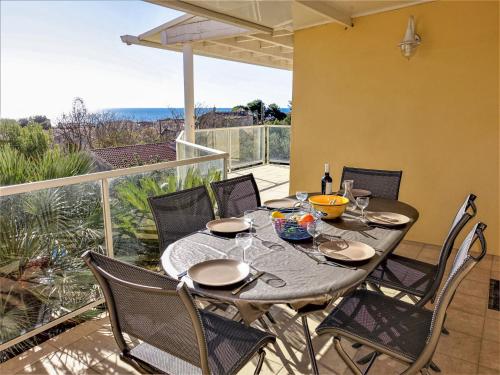 d'une table à manger et de chaises sur un balcon avec vue. dans l'établissement Holiday Home La Maison des Cades by Interhome, à Saint Pierre La Mer