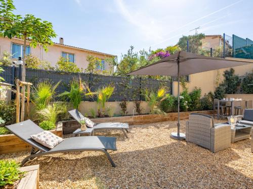 - une terrasse avec des chaises et un parasol dans l'arrière-cour dans l'établissement Apartment Akemi by Interhome, à Sainte-Maxime