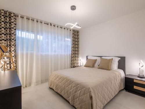 une chambre avec un lit et une grande fenêtre dans l'établissement Apartment Résidence Le Boréal-3 by Interhome, à Saint-Raphaël