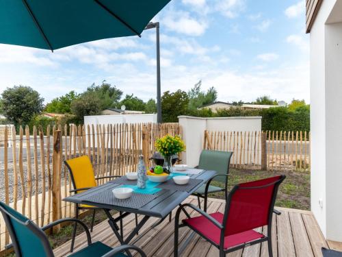 ein Tisch und Stühle auf einer Terrasse mit Sonnenschirm in der Unterkunft Apartment SC G01 by Interhome in Mimizan