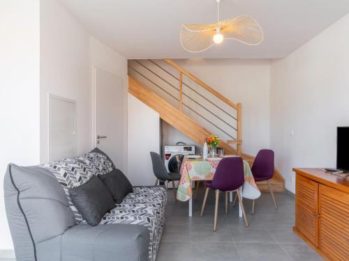 un salon avec un canapé et une table avec des chaises dans l'établissement Apartment SC G01 by Interhome, à Mimizan