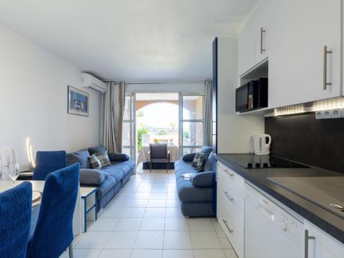 Il dispose d'une cuisine et d'un salon avec un canapé et une table. dans l'établissement Apartment Le Village - E1103 by Interhome, à Saint-Raphaël