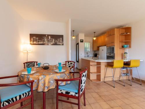 une salle à manger et une cuisine avec une table et des chaises dans l'établissement Holiday Home Les Jardins d'Hélios-3 by Interhome, à Carqueiranne