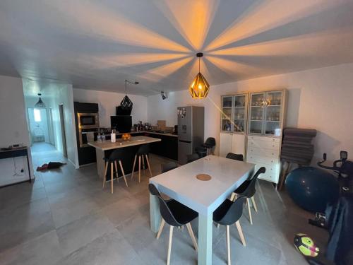 une cuisine avec une table et des chaises dans une pièce dans l'établissement Maison au cœur du médoc, à Cussac-Fort-Medoc
