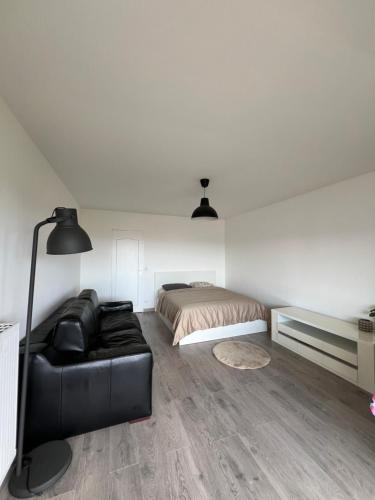 - une chambre avec un lit et un canapé en cuir noir dans l'établissement Appartement Les Oliviers, à Nice