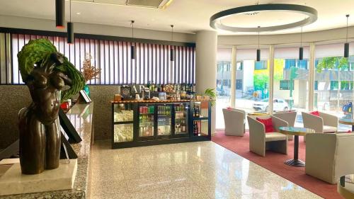 a lobby with a restaurant with a table and chairs at Hotel 3K Madrid in Lisbon