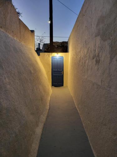 a hallway with a blue door in a building at Cave Houses Mesaria in Mesaria