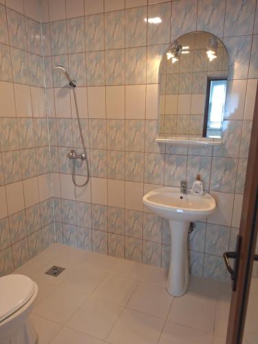 a bathroom with a sink and a shower with a mirror at Casa inflorita garsoniere etaj in Eforie Nord
