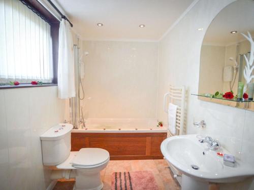 a bathroom with a toilet and a tub and a sink at Holiday Home An Cala by Interhome in Oban