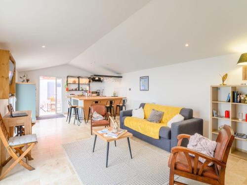 a living room with a couch and a table at Holiday Home Charme de Port Morin by Interhome in LʼÉpine