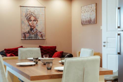a dining room with a table and a painting on the wall at MountSea Villa in Agios Nikolaos