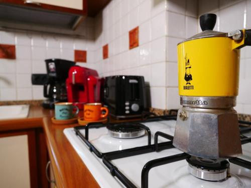 a kitchen stove with a yellow container on top of it at Vacanze Romane in Acilia