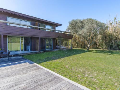 une maison avec une terrasse en bois et une cour dans l'établissement Apartment Le Trois du Petit Sperone by Interhome, à Bonifacio