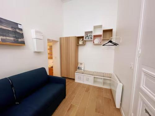 un salon avec un canapé bleu dans une pièce dans l'établissement Paris 9e Super Loft, à Paris