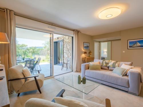 un salon avec un canapé et une porte coulissante en verre dans l'établissement Apartment Le Clos d'Alice-1 by Interhome, à Sainte-Maxime