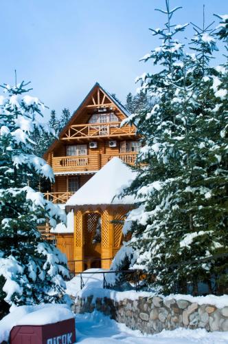 a log cabin in the snow with trees at Karpaty Migovo in Migovo