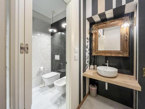 a bathroom with a sink and a toilet and a mirror at Casa del viaggiatore in Turin