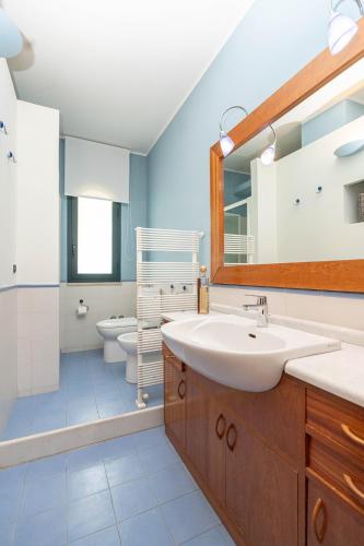 a bathroom with a sink and a toilet and a mirror at Villa Marta Luxury Sea View and Spa in Taormina