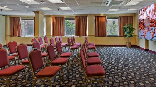 a conference room with red chairs and a screen at Holiday Inn Washington-Central/White House by IHG in Washington