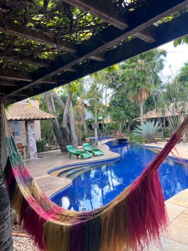 a resort with a hammock and a swimming pool at Pousada Vila Parnaíba in Parnaíba