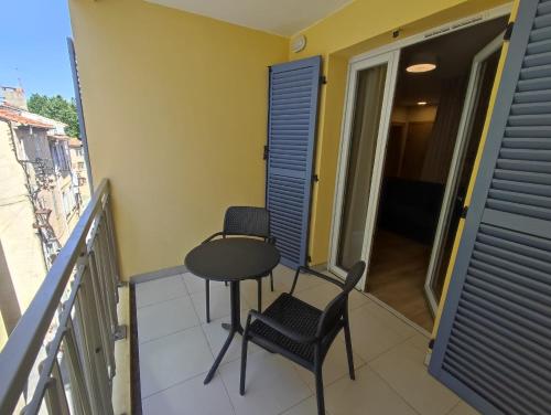 a balcony with two chairs and a table at ZENAO Fréjus in Fréjus