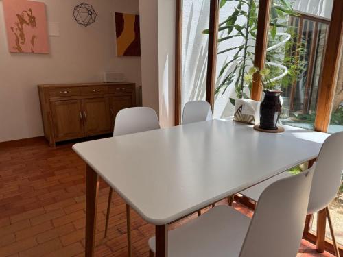 a white table and chairs in a room with a window at AOMO ART SPACE Hostel in Oeiras