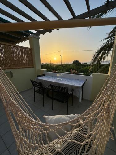 a hammock on a patio with a table and chairs at Breathe easy living in Tigaki