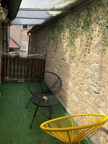 a chair and a table on a patio at Au nid d amour in Chablis