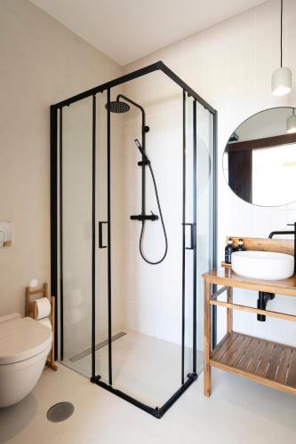 a bathroom with a glass shower and a toilet at Casa da Serra in Buarcos