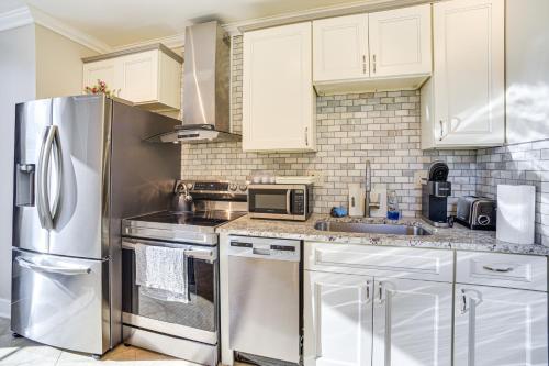 a kitchen with white cabinets and a stainless steel refrigerator at Walk to Dtwn and Waterfront Roomy Troy Apt in Troy