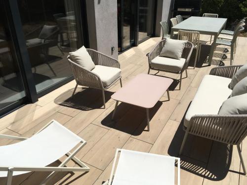 une rangée de chaises et de tables sur une terrasse dans l'établissement Casa Corsa - T4 Neuf de Standing avec Terrasse Spacieuse, à Bonifacio