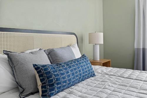 a bedroom with a bed with blue and gray pillows at Surf Loft in Saint Joseph