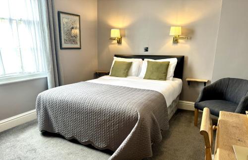 a hotel room with a bed and a chair at Royal Oak Hotel, Garstang in Garstang
